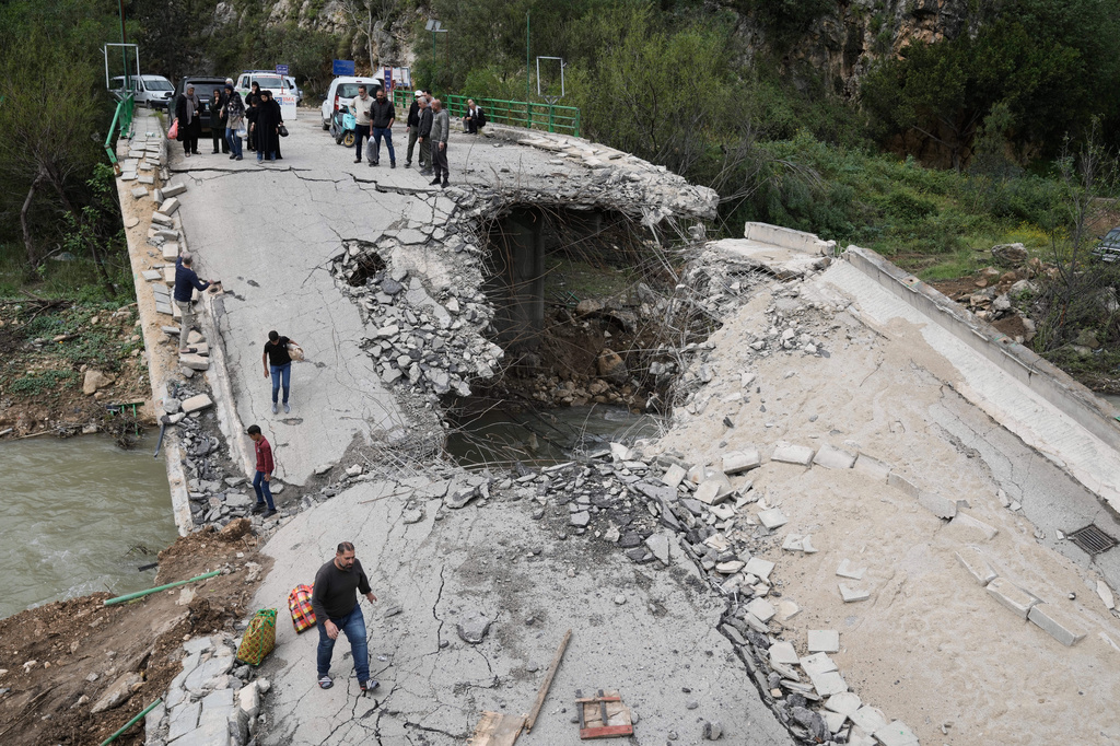 Displaced people cross a destroyed bridge as they return to their villages, following a ceasefire between Hezbollah and Israel, in Tayr Felsay village, southern Lebanon, Sunday, April 19, 2026. (AP Photo/Bilal Hussein)