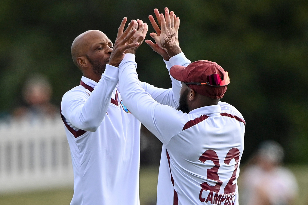 West Indies' Roston Chase, left, and teammate John Campbell celebrate after taking the wicket of New Zealand's Nathan Smith during their cricket test match in Christchurch, New Zealand, Tuesday, Dec. 2, 2025. (John Davidson/Photosport via AP)