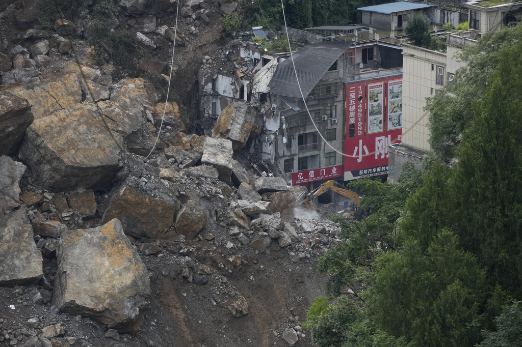 Rescuers use heavy machinery to clear rubble to search for trapped persons on the site of a landslide in Pengshui County, southwestern China's Chongqing on Sunday, July 19, 2026. (AP Photo/Andy Wong)