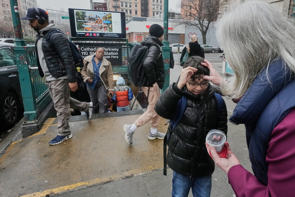 Lorraine Simmons, right, Sacristan of The Cathedral Church of Saint John the Divine, distributes "Ashes To Go" for Ash Wednesday at a subway stop on New York's Upper West Side, Wednesday, Feb. 18, 2026. (AP Photo/Richard Drew)