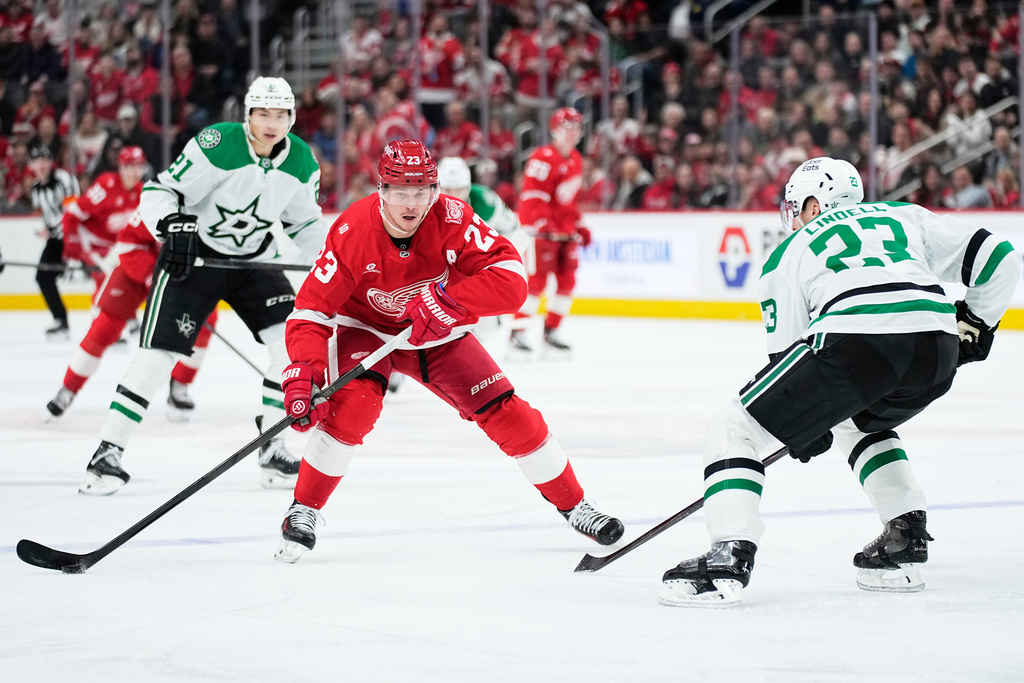 Detroit Red Wings left wing Lucas Raymond, left, moves the puck against Dallas Stars defenseman Esa Lindell during the second period of an NHL hockey game Tuesday, Dec. 23, 2025, in Detroit. (AP Photo/Ryan Sun)
