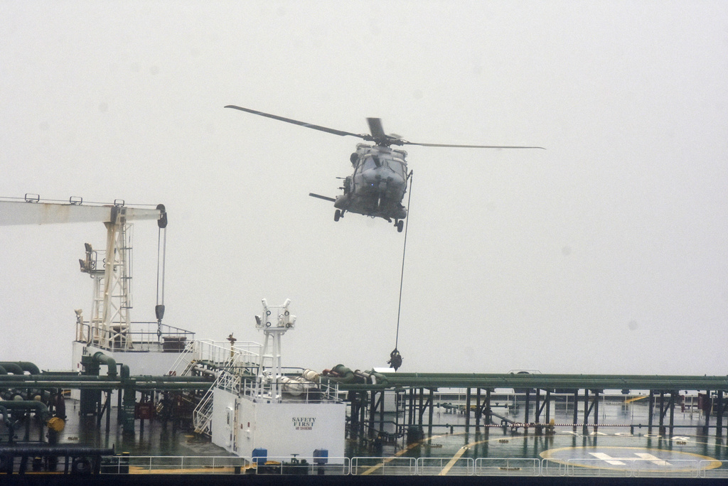 In this handout photo provided by the French Army, French soldiers use a rope from a NH90 helicopter intercepts an oil tanker that was traveling from Russia under international sanctions, on the Atlantic Sea, Sunday, May 31, 2026. (French Army via AP)