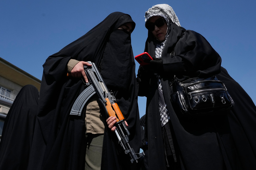 A woman member of the Basij paramilitary, affiliated with Iran's Revolutionary Guard, holds her gun during a state-organized rally in support of the supreme leader marking National Girl's Day in Tehran, Iran, Friday, April 17, 2026. (AP Photo/Vahid Salemi)