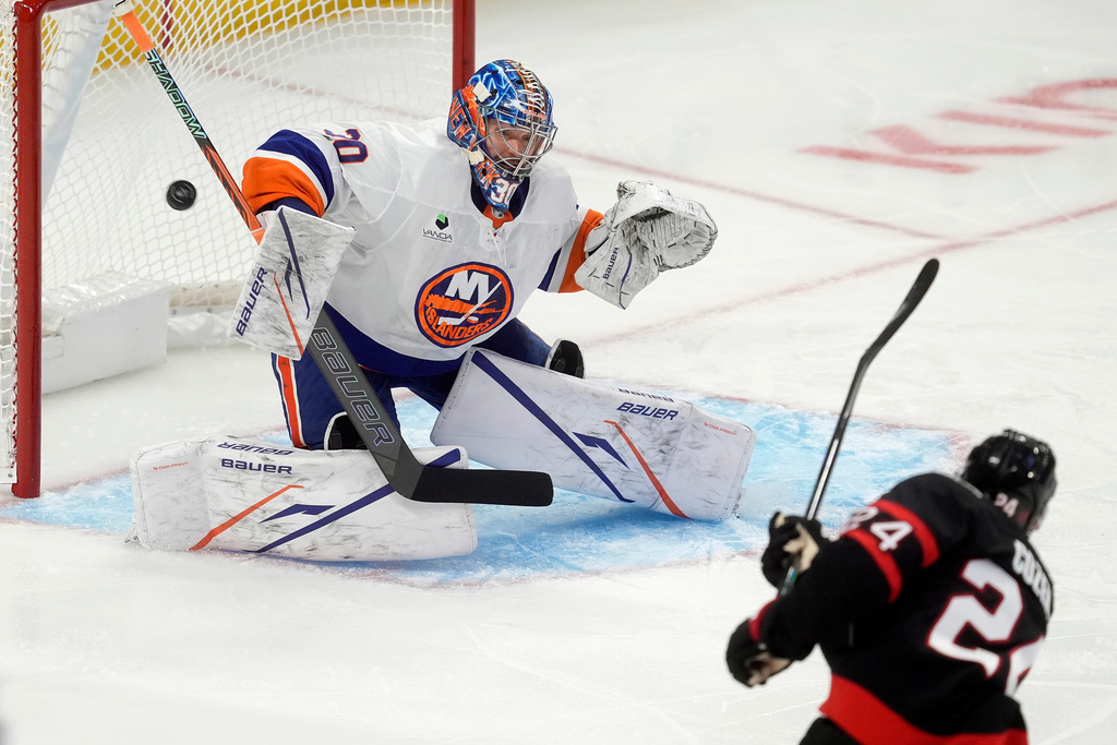 New York Islanders goaltender Ilya Sorokin (30) deflects a shot from Ottawa Senators center Dylan Cozens (24) during the first period of an NHL hockey game in Ottawa, Ontario, Saturday, Oct. 18, 2025. (Adrian Wyld/The Canadian Press via AP)