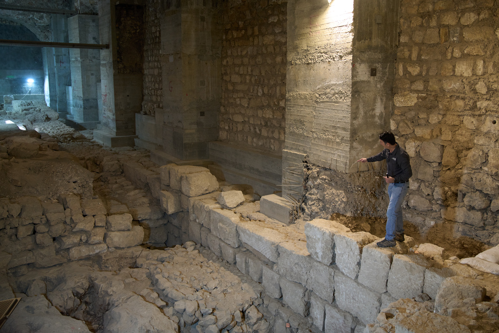 The Jerusalem Regional Archaeologist for the Israel Antiquities Authority, Dr. Amit Re'im, shows a section of an excavation site where, according to the institution, a city wall from the Hasmonean period, dating to the late 2nd century BCE, was uncovered under the Tower of David Citadel Museum, in the Old City of Jerusalem, Monday, Dec. 8, 2025. (AP Photo/Leo Correa)