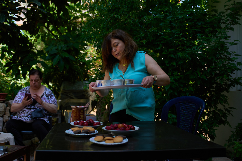 Lolitta Costantine, right, serves coffee as Wadiaa Salloum sits in the garden of her home in the southern town of Jdeidat Marjayoun, Lebanon, Thursday, June 11, 2026. (AP Photo/Hassan Ammar) CORRECTION: City corrected to Jdeidat Marjayoun, instead of Marjayoun