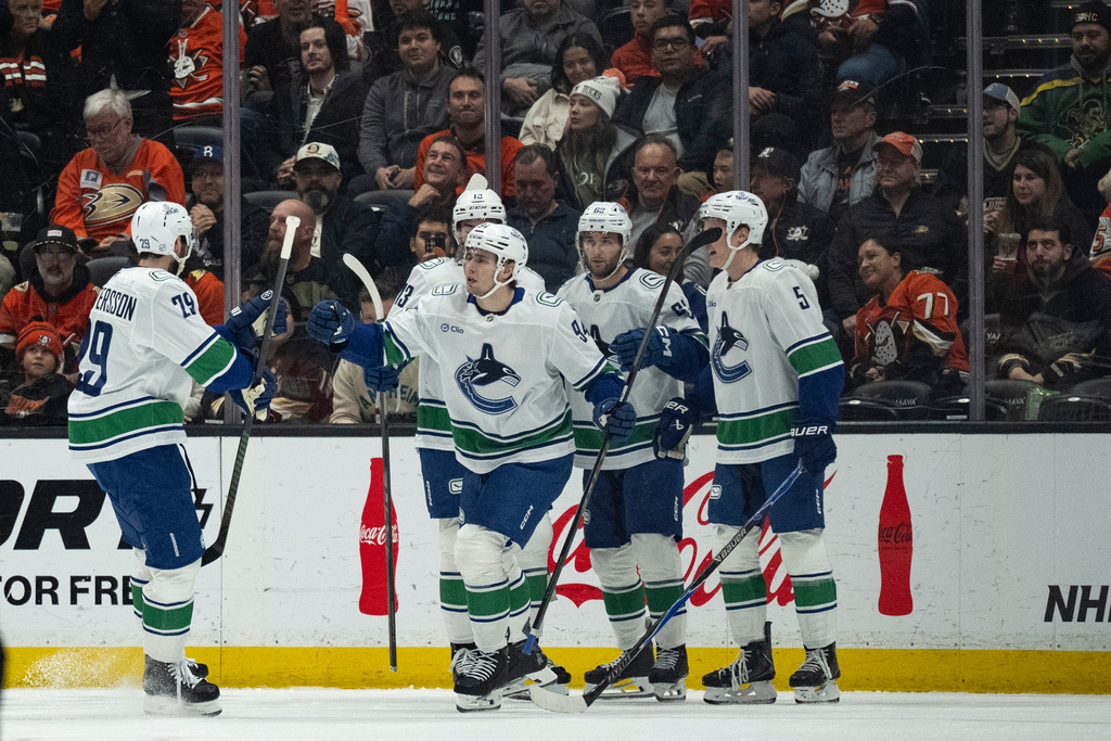 Vancouver Canucks players celebrate a goal by center Linus Karlsson (94) during the first period of an NHL hockey game against the Anaheim Ducks, Wednesday, Nov. 26, 2025, in Anaheim, Calif. (AP Photo/Kyusung Gong)