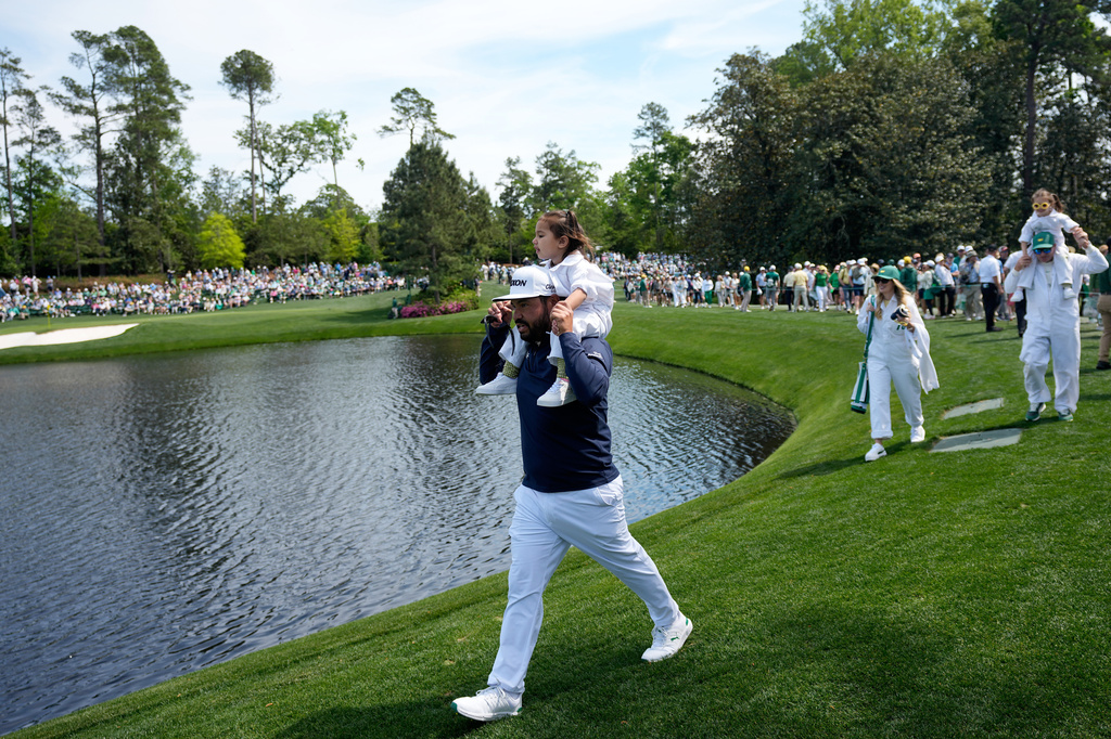 J.J. Spaun, left, carries his daughter, Violet Windsor, on his shoulder on the sixth hole during par-3 contest ahead of the Masters golf tournament at the Augusta National Golf Club, Wednesday, April 8, 2026, in Augusta, Ga. (AP Photo/Eric Gay)