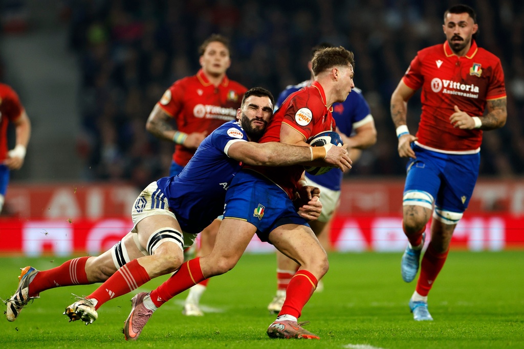 Italy's Leonardo Marin, center, is tackled by France's Charles Ollivon during the Six Nations rugby union match between France and Italy in Lille, France, Sunday, Feb. 22, 2026. (AP Photo/Jean-Francois Badias)