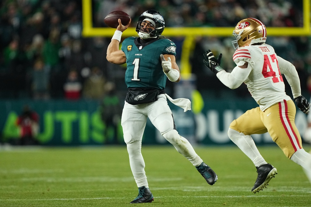 Philadelphia Eagles quarterback Jalen Hurts (1) looks to pass as San Francisco 49ers defensive end Bryce Huff (47) defends during the second half of an NFL wild-card playoff football game Sunday, Jan. 11, 2026, in Philadelphia. (AP Photo/Matt Rourke)