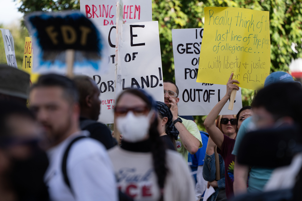 People protest outside a U.S. Immigration and Customs Enforcement facility on Sunday, Sept. 28, 2025, in Portland, Ore. (AP Photo/Jenny Kane)
