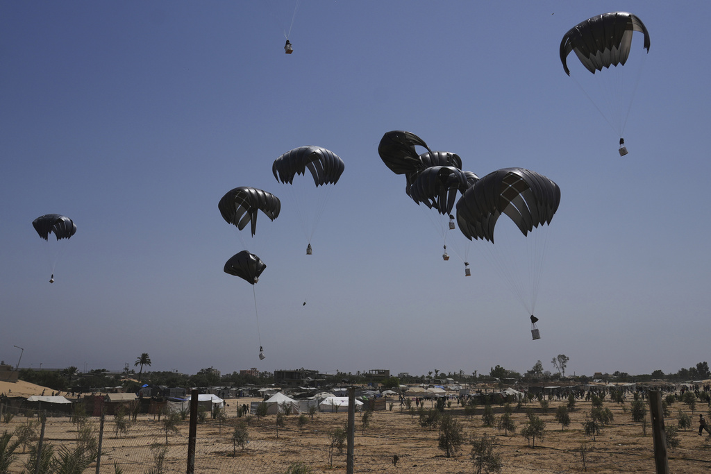 Parachutes drop supplies into Deir al-Balah, central Gaza Strip, Tuesday, Aug. 19, 2025. (AP Photo/Abdel Kareem Hana)