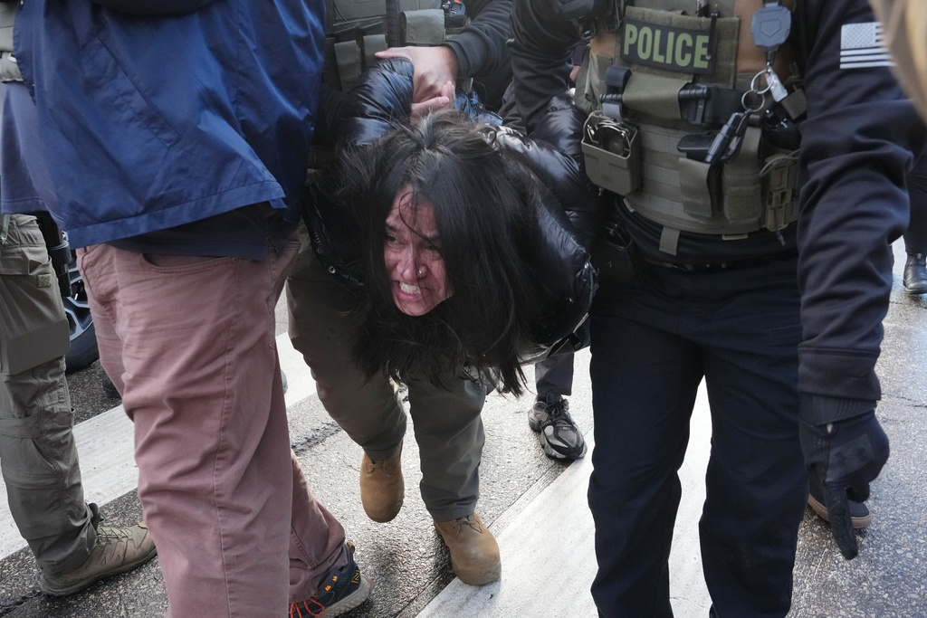 CORRECTS FROM A PROTESTER TO A PERSON - A person is detained by federal agents near the scene where Renee Good was fatally shot by an ICE officer last week, Tuesday, Jan. 13, 2026, in Minneapolis. (AP Photo/Adam Gray)