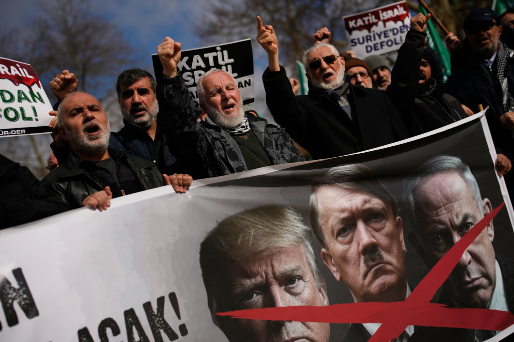 People chant slogans as they protest against U.S. and Israeli strikes on Iran, in Istanbul, Turkey, Sunday, March 1, 2026. Boards read in Turkish: "Israel killer". (AP Photo/Emrah Gurel)