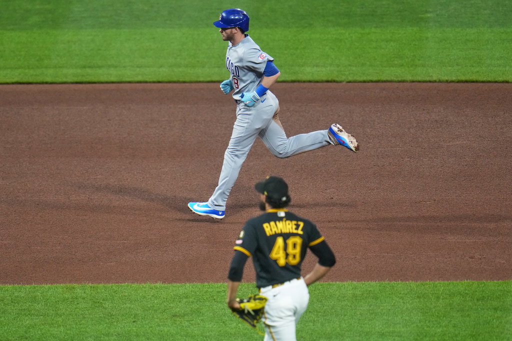 Chicago Cubs' Ian Happ, top, rounds the bases after hitting a three-run home run off Pittsburgh Pirates pitcher Yohan Ramírez (49) during the seventh inning of a baseball game in Pittsburgh, Wednesday, May 27, 2026. (AP Photo/Gene J. Puskar)