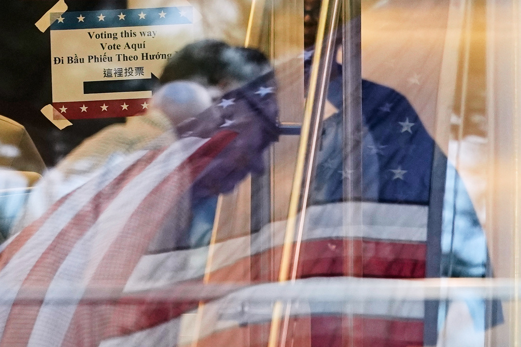 A voter makes his way inside a polling location, where a U.S. flag is reflected on the windows, Tuesday, March 3, 2026, in Spring, Texas. (AP Photo/David J. Phillip)