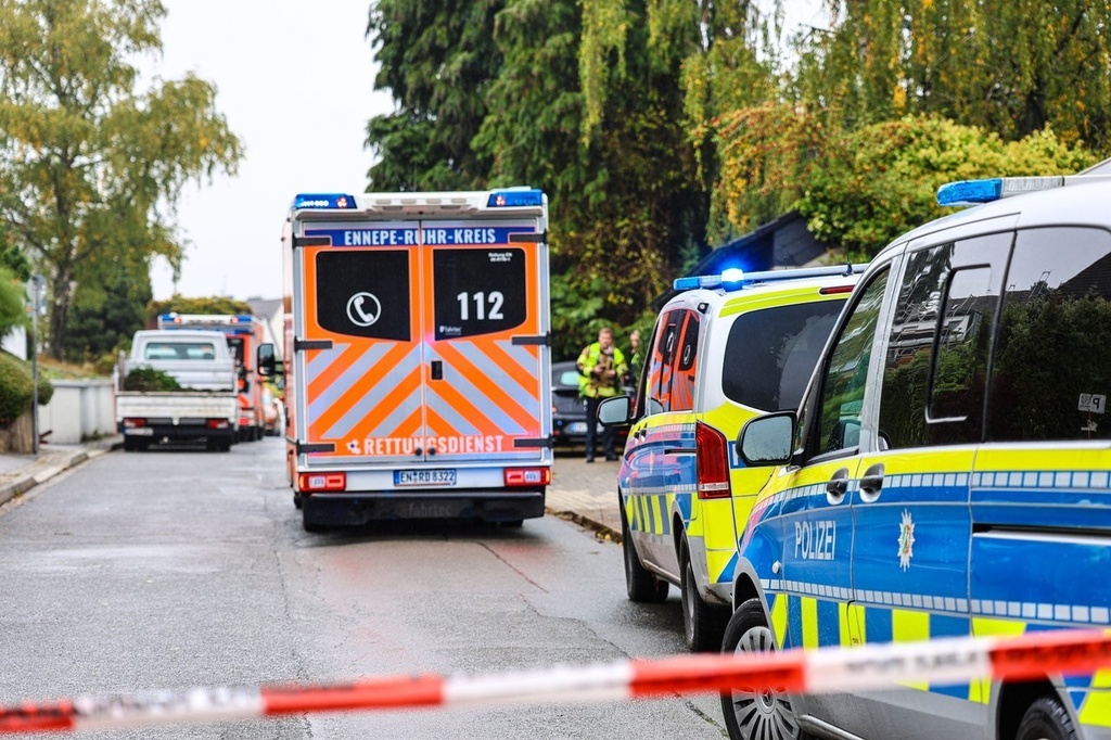 An ambulance stands in front of police cars on a street in Herdecke, Germany, Tuesday, Oct. 7, 2025, after the newly elected mayor of Herdecke, Iris Stalzer, has been found critically injured in her apartment. (Alex Talash/dpa via AP)