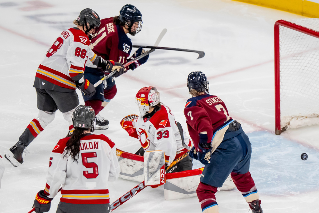 Montreal Victoire's Abby Roque (11) scores on Ottawa Charge goaltender Gwyneth Philips (33) during overtime of a PWHL playoff hockey game in Laval, Quebec, Thursday, May 14, 2026. (Christopher Katsarov/The Canadian Press via AP)
