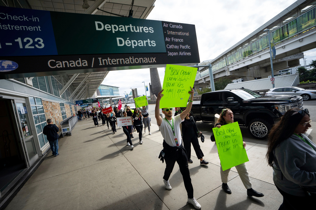 Picketers march around the departures level at the Vancouver International Airport in Richmond, British Columbia, Sunday, Aug. 17, 2025. (Ethan Cairns/The Canadian Press via AP)