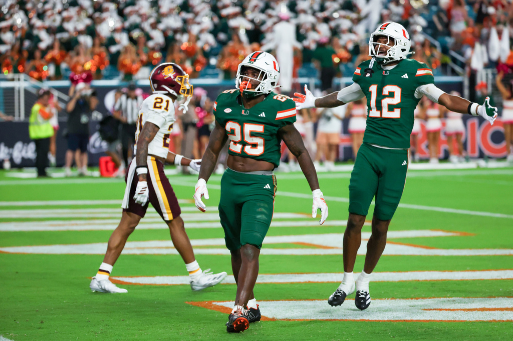 Miami running back Chris Wheatley-Humphrey (25) celebrates with wide receiver Somourian Wingo (12) after scoring a touchdown as Central Michigan defensive back Jamari Allen (21) walks off during the second half of an NCAA college football game, Saturday, Sept. 26, 2026, in Miami Gardens, Fla. (AP Photo/David Santiago)