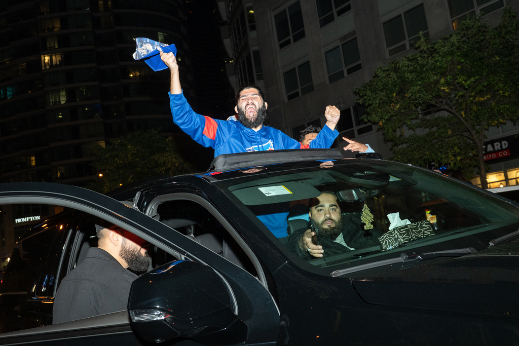 Toronto Blue Jays fans celebrate after the team beat the Seattle Mariners to win the American League Championship Series in Toronto, Monday, Oct. 20, 2025. (Laura Proctor/The Canadian Press via AP)