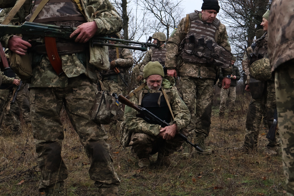 In this photo provided by Ukraine's 65th Mechanized Brigade press service, recruits rest after drills at a training ground in the Zaporizhzhia region, Ukraine, Friday, Dec. 12, 2025. (Andriy Andriyenko/Ukraine's 65th Mechanized Brigade via AP)