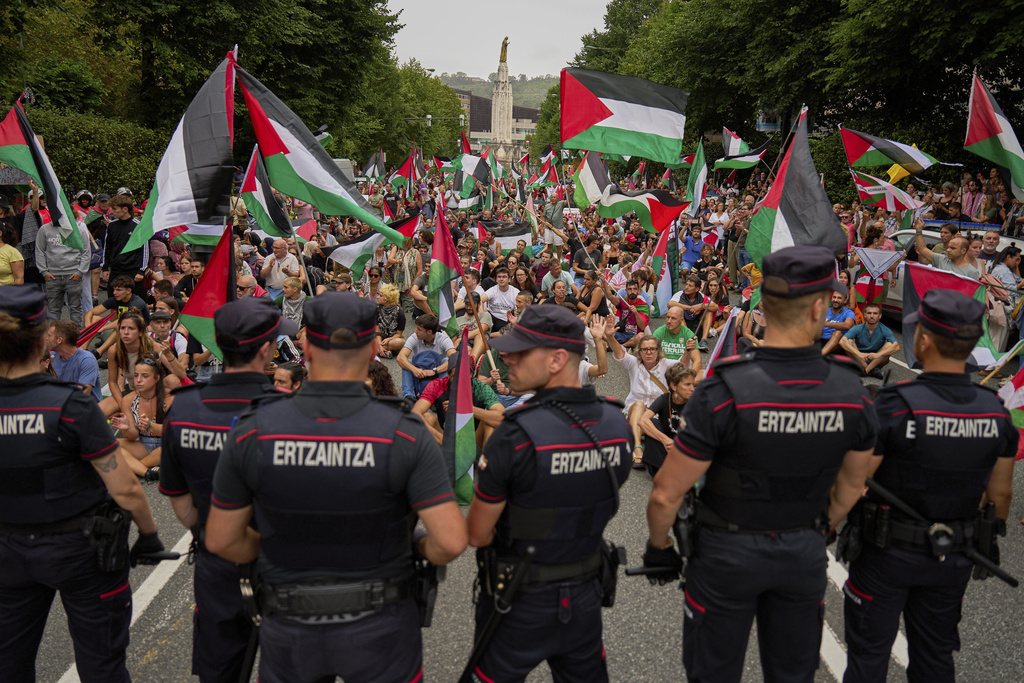 People holding Palestinian flags sit on the street after disrupting the eleventh stage of the Spanish Vuelta cycling race, from Bilbao to Bilbao, Spain, Wednesday, Sept. 3, 2025. (AP Photo/Miguel Oses)
