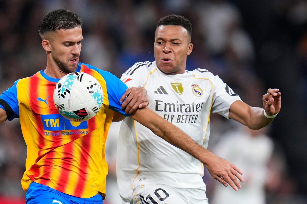 Real Madrid's Kylian Mbappe, right, and Valencia's Jose Copete challenge for the ball during the Spanish La Liga soccer match between Real Madrid and Valencia in Madrid, Spain, Saturday, Nov. 1, 2025. (AP Photo/Manu Fernandez)