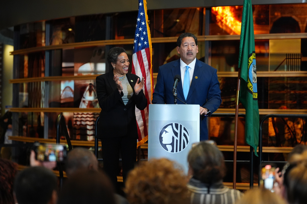 Seattle Mayor Bruce Harrell, right, looks on as wife Joanne Harrell claps during his concession speech at Seattle City Hall Thursday, Nov. 13, 2025, in Seattle. (AP Photo/Lindsey Wasson)