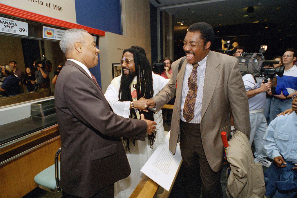 FILE - From left: Joseph McNeil, Jibreel Khazan, and Franklin McCain greet each other during an opening of a new exhibit at the Smithsonian Institution's National Museum of American History in Washington, Jan. 14, 1995. (AP Photo/Tyler Mallory, File)