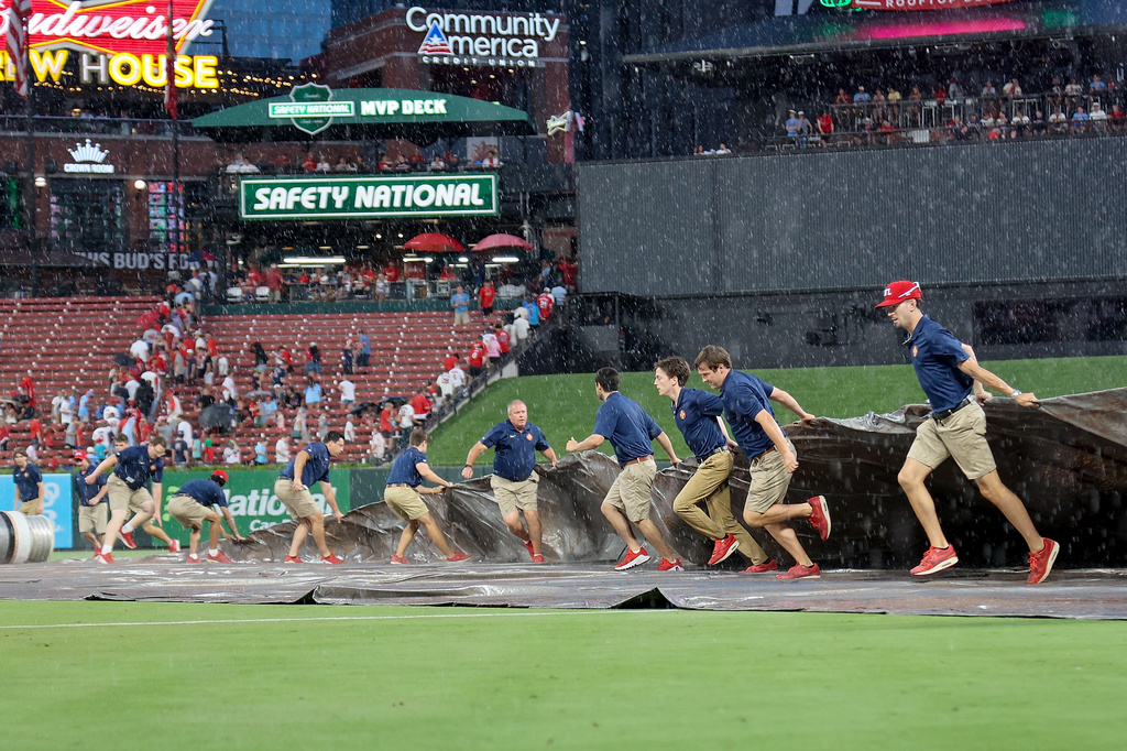 Members of the St. Louis Cardinals grounds crew tarp the field during a rain delay at the top of the fourth inning of a baseball game against the Atlanta Braves Friday, July 10, 2026, in St. Louis. (AP Photo/Scott Kane)