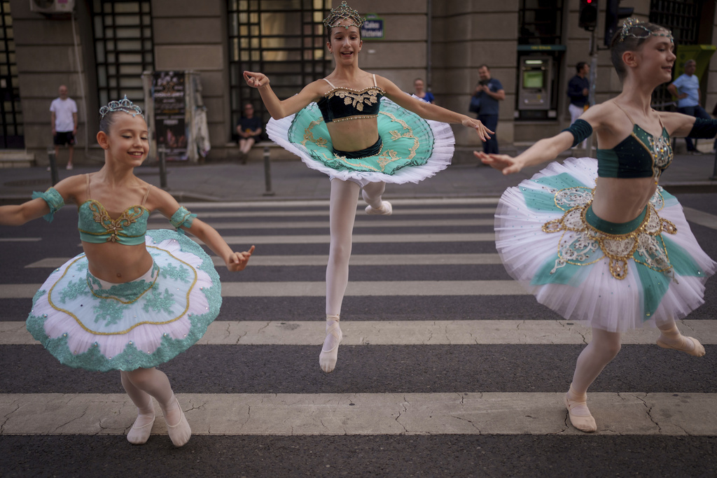 Dora, 10, left, Irina, 11, center, and Sandra, 12, of the Romanian National Opera's Ballet Studio, perform outside the National History Museum of Romania during Dance Night, an event featuring a wide variety of dance styles performed on the Calea Victoriei avenue in Bucharest, Romania, Saturday, Aug. 23, 2025. (AP Photo/Andreea Alexandru)