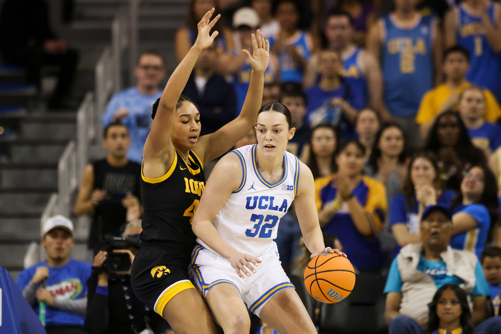 UCLA forward Angela Dugalić (32) dribbles against Iowa forward Hannah Stuelke, left, during the first half of an NCAA college basketball game, Sunday, Feb. 1, 2026, in Los Angeles. (AP Photo/Jessie Alcheh)