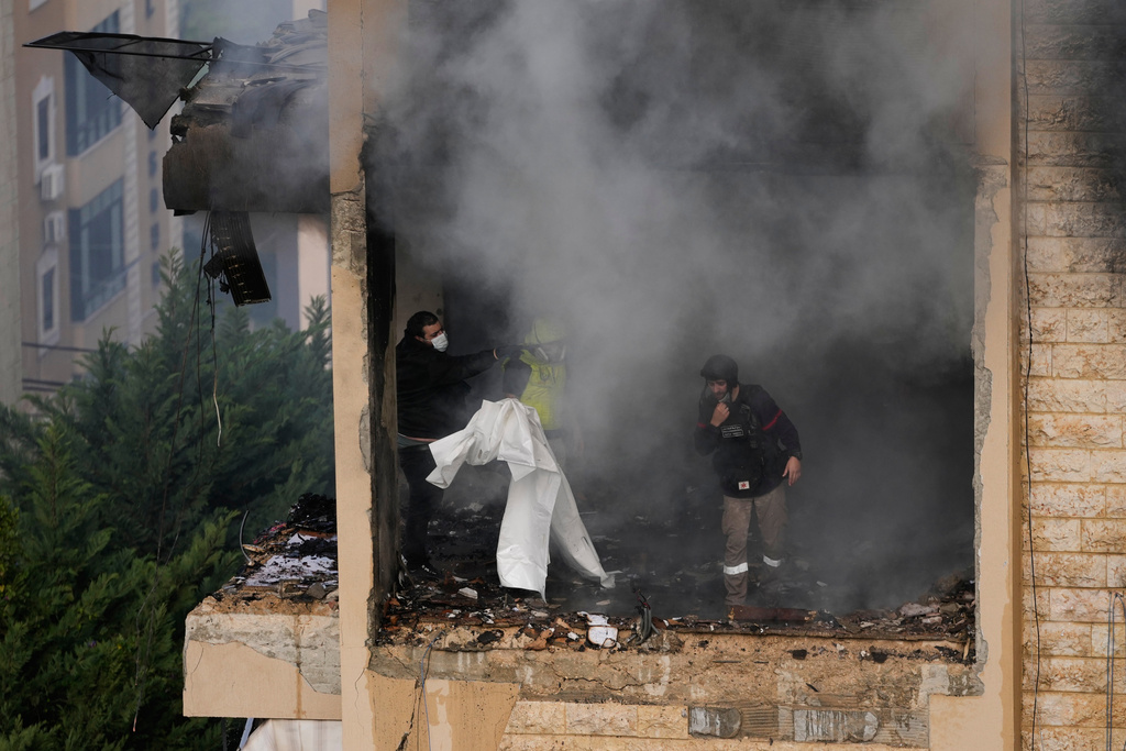 Rescue workers inspect an apartment damaged in an Israeli airstrike as thick smoke fills the building in the southern port city of Sidon, Lebanon, Saturday, March 14, 2026. (AP Photo/Mohammad Zaatari)