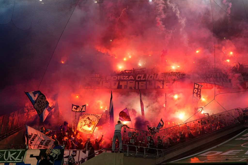 Hamburg supporters fire flares during the German Bundesliga soccer match between Cologne and Hamburger SV, in Cologne, Germany, Sunday, Nov. 2, 2025. (AP Photo/Martin Meissner)