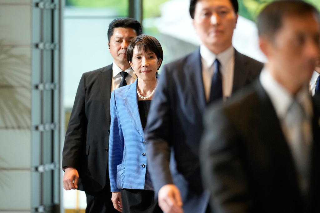 Japan's newly elected Prime Minister Sanae Takaichi, center, arrives at the prime minister's office in Tokyo, Japan, Tuesday, Oct. 21, 2025.(AP Photo/Eugene Hoshiko)