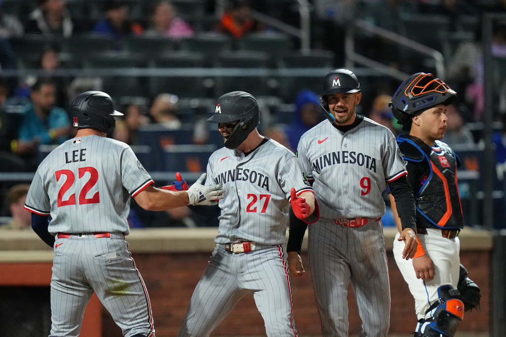 New York Mets catcher Francisco Alvarez, right, looks away as Minnesota Twins' Ryan Jeffers (27) celebrates with Trevor Larnach (9) and Brooks Lee (22) after Jeffers hit a grand slam during the eighth inning of a baseball game Thursday, April 23, 2026, in New York. (AP Photo/Frank Franklin II)