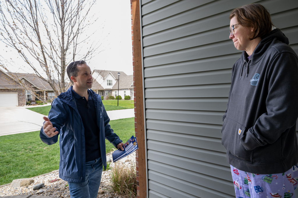 Julie Wise, 48, speaks with Indiana state Sen. Spencer Deery, R-West Lafayette, who represents District 23, as he canvasses a neighborhood, Saturday, April 11, 2026, in West Lafayette, Ind. (AP Photo/Doug McSchooler)