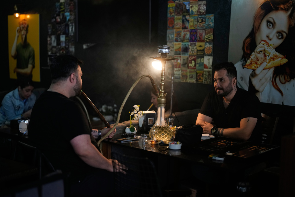 Nadr Rahim, right, sits with a friend at an Iranian coffee shop in Istanbul on Tuesday, April 14, 2026. (AP Photo/Khalil Hamra)