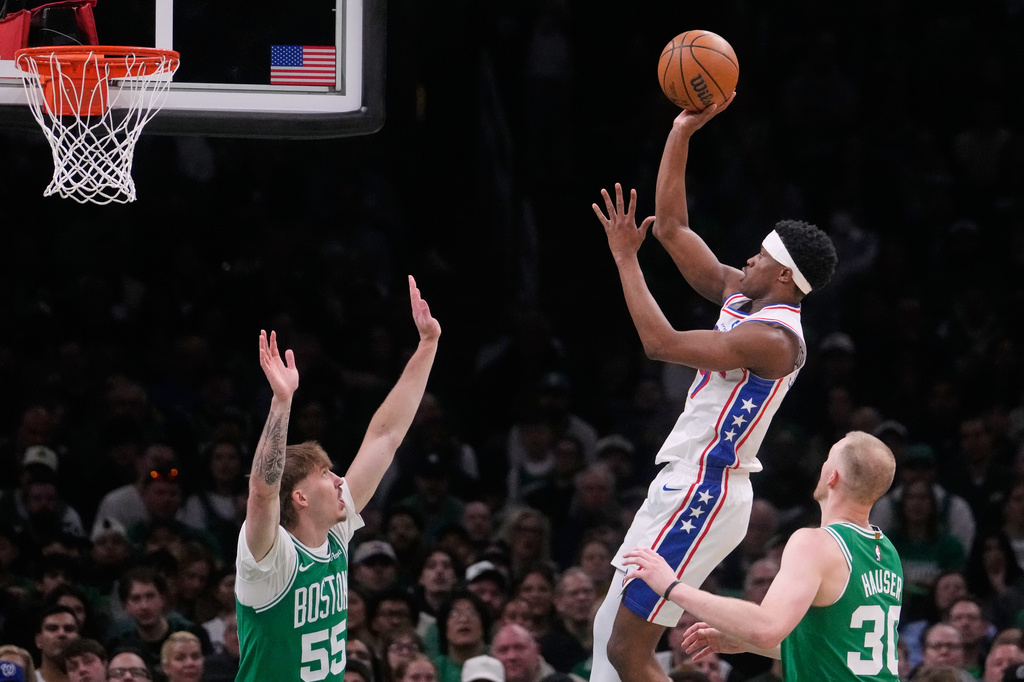 Philadelphia 76ers guard Vj Edgecombe takes a shot against Boston Celtics guard Baylor Scheierman (55) and forward Sam Hauser (30) during the first half of Game 2 of a first-round NBA playoffs basketball series, Tuesday, April 21, 2026, in Boston. (AP Photo/Charles Krupa)
