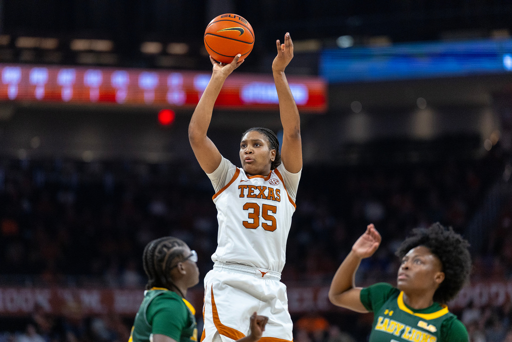 Texas forward Madison Booker (35) goes up to score over Southeastern Louisiana guards Fatime Seck, left, and guard Aliyah Collins, right, during the second half of an NCAA college basketball game Sunday, Dec. 28, 2025, in Austin, Texas. (AP Photo/Stephen Spillman)