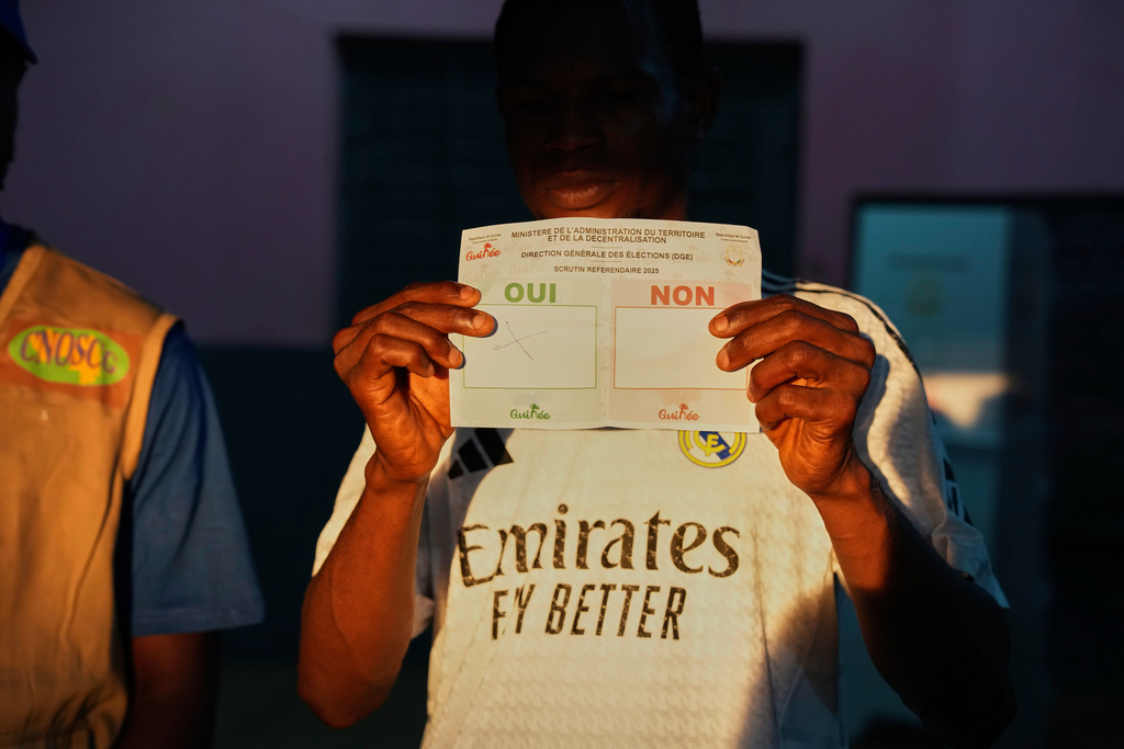 Officials count ballots at a polling station as polls close during the constitutional referendum in Conakry, Guinea, Sunday, Sept. 21, 2025. (AP Photo/Misper Apawu)