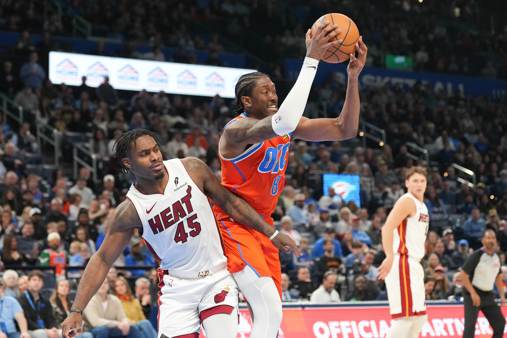 Oklahoma City Thunder guard Jalen Williams (8) grabs a rebound in front of Miami Heat guard Davion Mitchell (45) during the second half of an NBA basketball game, Sunday, Jan. 11, 2026, in Oklahoma City. (AP Photo/Kyle Phillips)