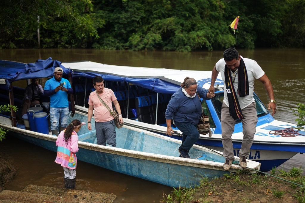 Jani Silva, 63, gets off a boat, on the outskirts of Puerto Asis, Colombia, Wednesday, Nov. 26, 2025. (AP Photo/Ivan Valencia)