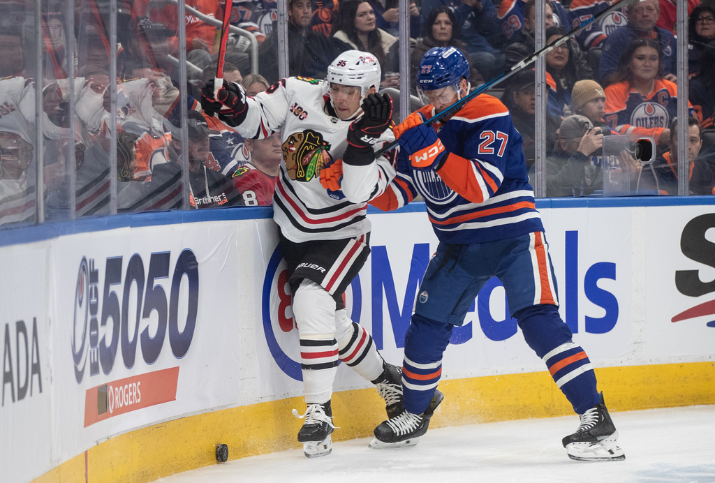 Chicago Blackhawks' Ilya Mikheyev (95) is checked by Edmonton Oilers' Brett Kulak (27) during first period NHL action, in Edmonton on Saturday, Nov. 1, 2025. (Jason Franson/The Canadian Press via AP)