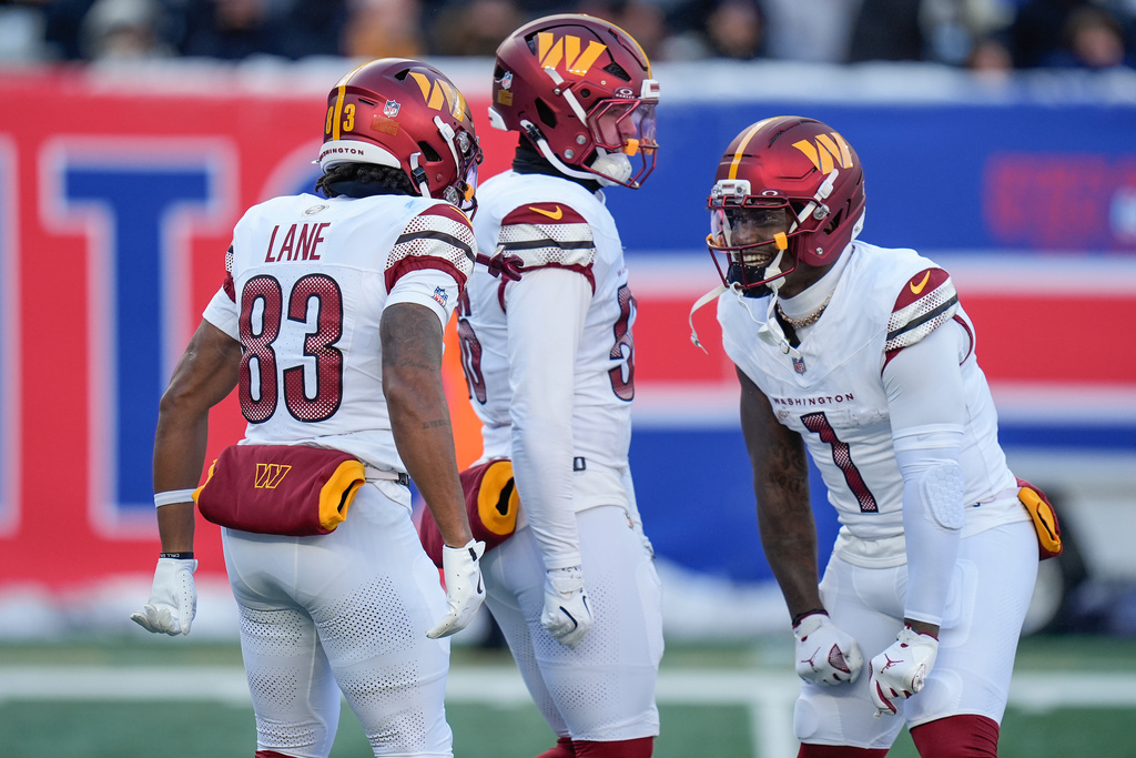 Washington Commanders wide receiver Jaylin Lane (83) celebrates with wide receiver Deebo Samuel Sr. (1) after returning a punt for a touchdown against the New York Giants during the second quarter of an NFL football game, Sunday, Dec. 14, 2025, in East Rutherford, N.J. (AP Photo/Seth Wenig)