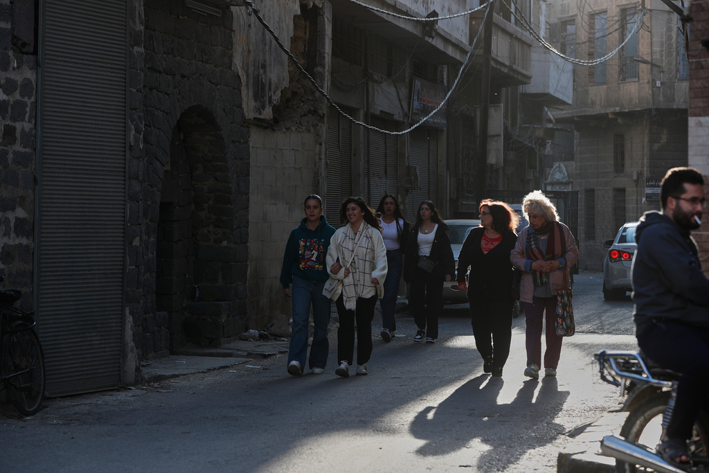 People walk through a street in the old city of Homs, Syria, Friday, Nov. 21, 2025. (AP Photo/Omar Sanadiki)