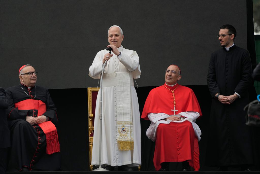 Cardinal Francesco Montenegro, left, and from right, Father Paolo Stacchiotti and Cardinal Baldo Reina listen to Pope Leo XIV during a visit to the parish complex of Santa Maria della Presentazione on the outskirts of Rome, Sunday, March 8, 2026. (AP Photo/Gregorio Borgia)