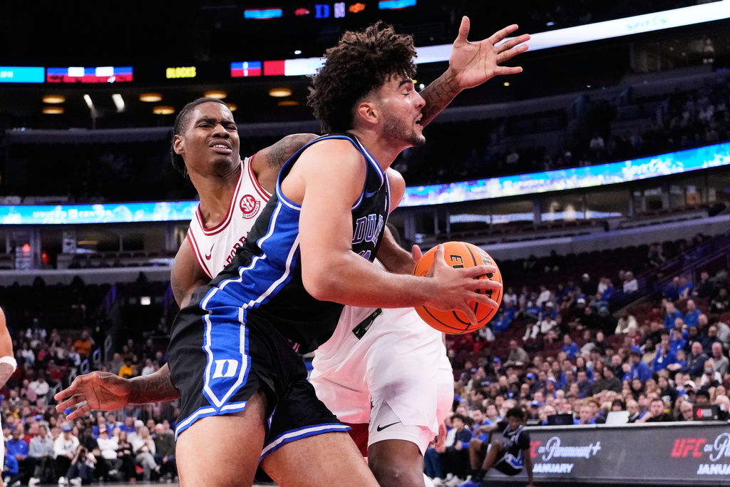 Duke forward Cameron Boozer, right, drives to the basket as Arkansas forward Nick Pringle, left, defends during the first half of an NCAA college basketball game in the CBS Sports Thanksgiving Classic tournament Thursday, Nov. 27, 2025, in Chicago. (AP Photo/Nam Y. Huh)