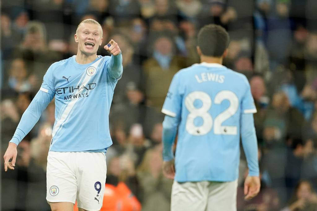 Manchester City's Erling Haaland, left, gestures to teammates Manchester City's Rico Lewis, as he celebrates after scoring his sides third goal of the game during the English Premier League soccer match between Manchester City and West Ham United in Manchester, England, Saturday, Dec. 20, 2025. (AP Photo/Dave Thompson)